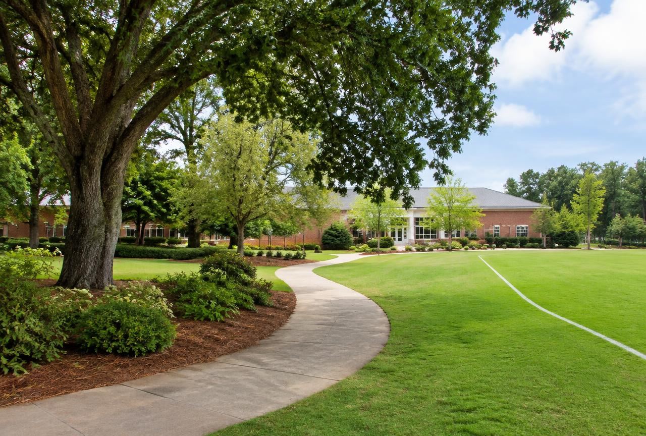 Institutional campus grounds with walking path and athletic field